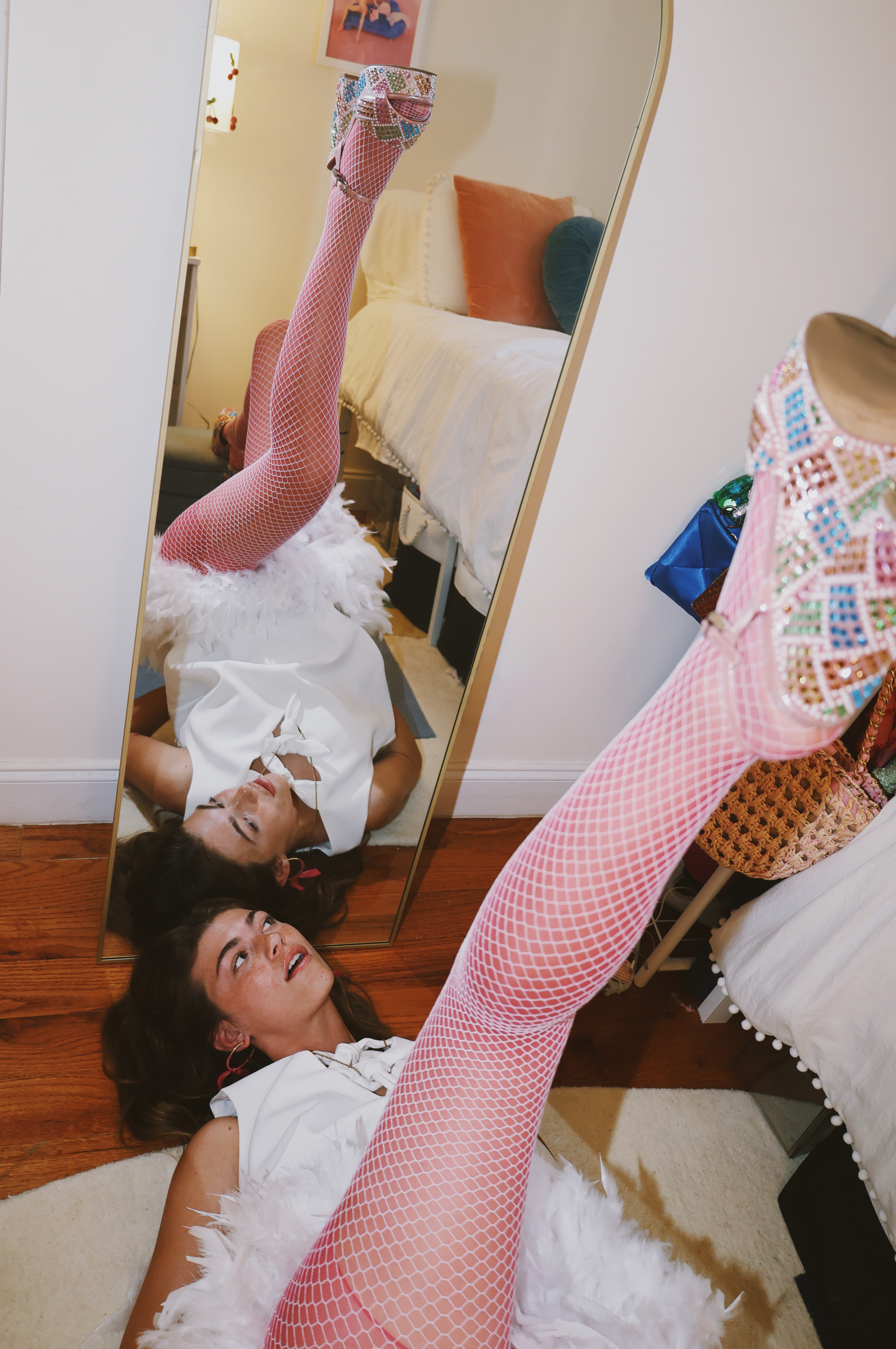 Model Kennedy Crawford poses in pink tights and white fishnet tights. Photographed by Olivia Bokesch for Sheer Denier